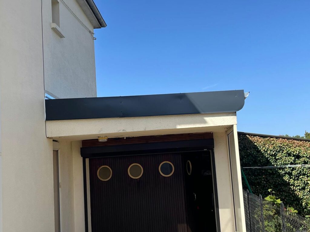 Habillage anthracite en bordure de la toiture rénovée au-dessus du garage