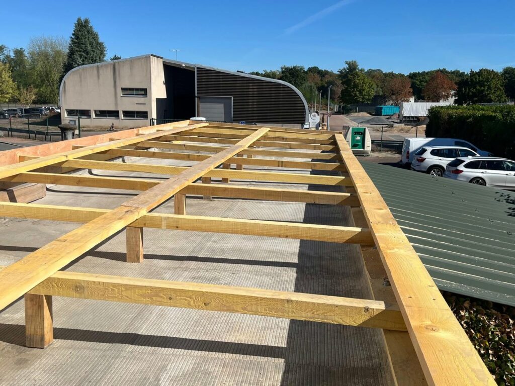 Ossature bois créant la pente au-dessus du toit-terrasse existant