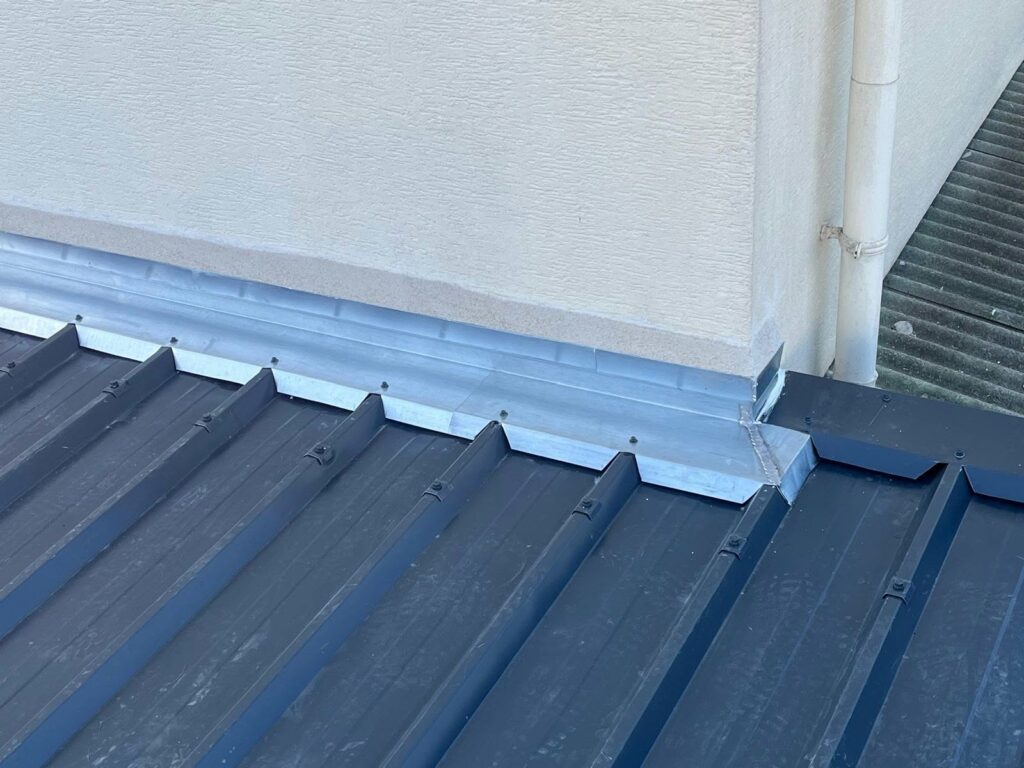 Solin métallique au raccord entre le mur et la couverture en bac acier