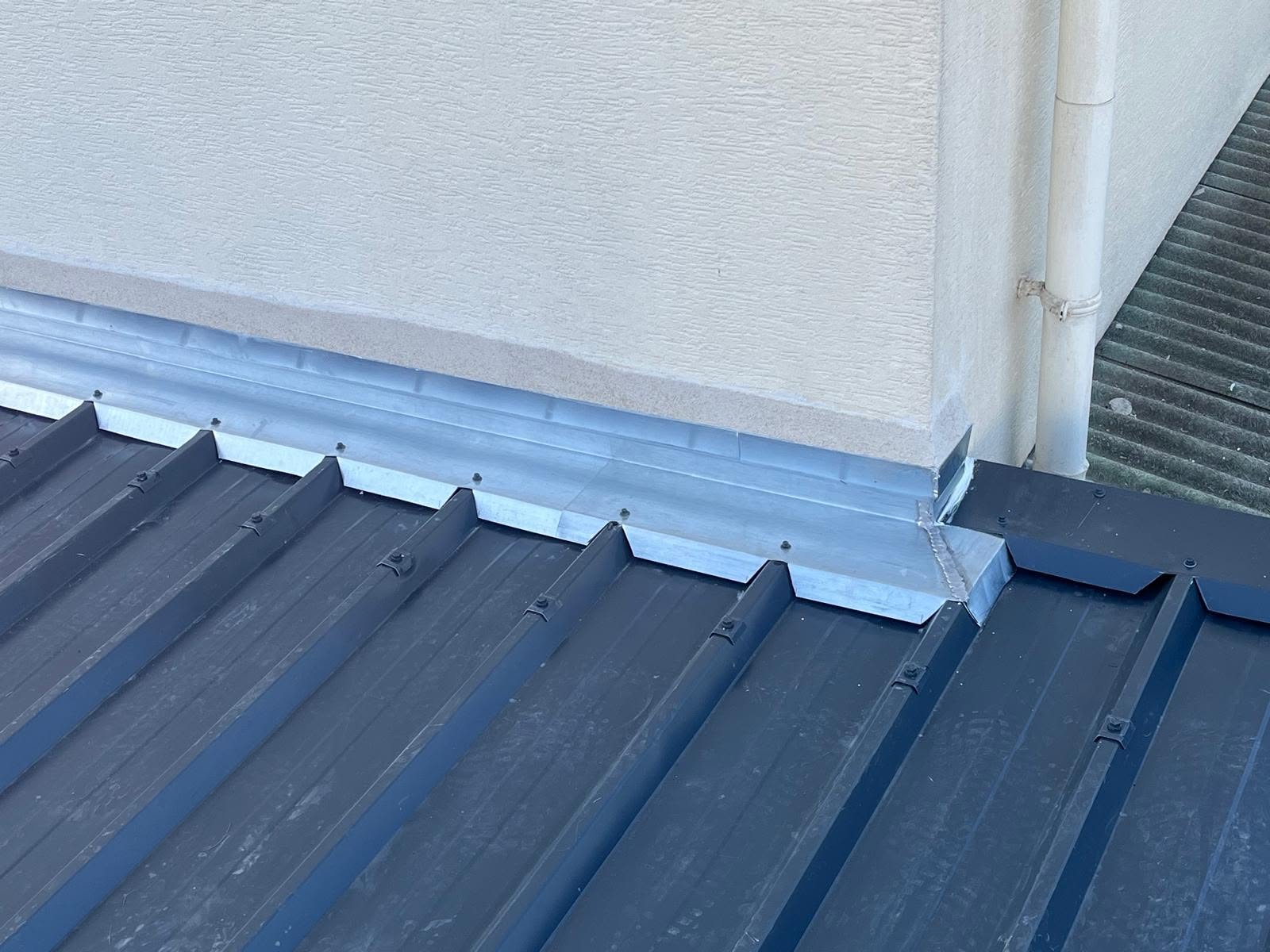 Solin métallique au raccord entre le mur et la couverture en bac acier