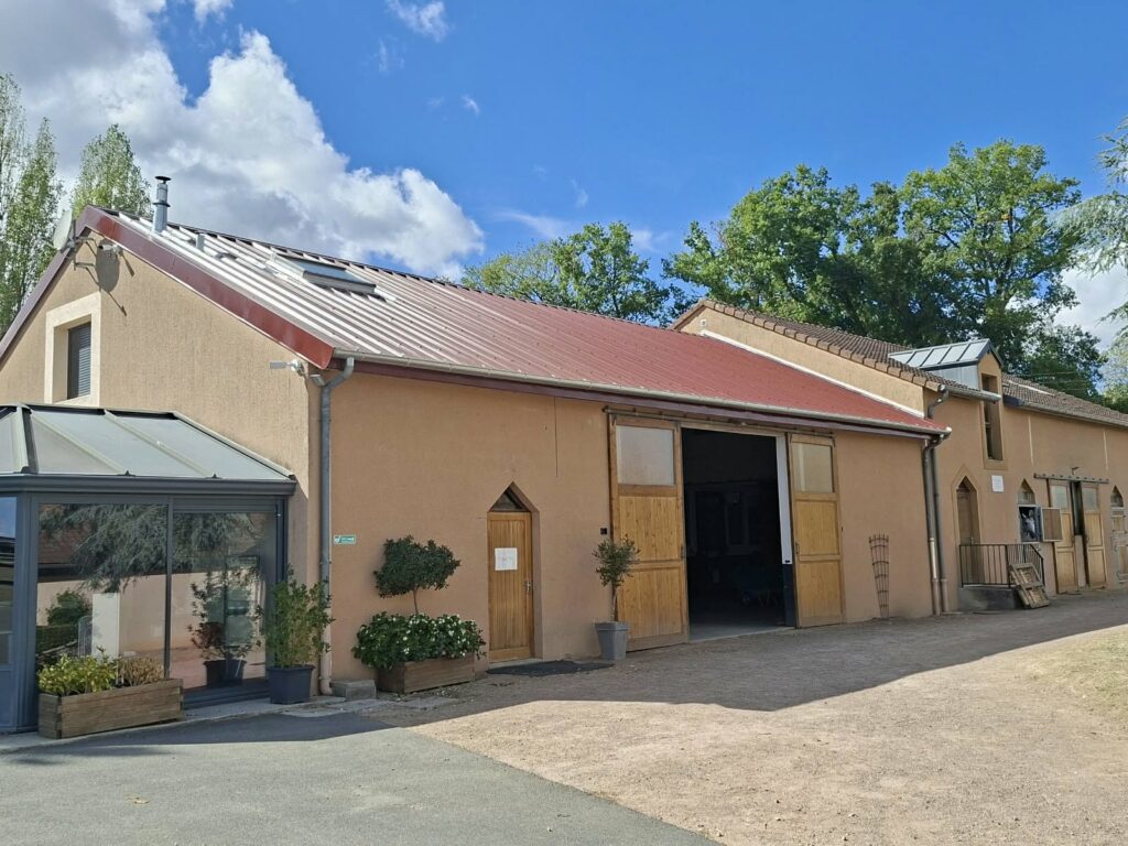 Vue d’ensemble du bâtiment du Haras de Cercy-la-Tour avec sa toiture rénovée et ses fenêtres de toit