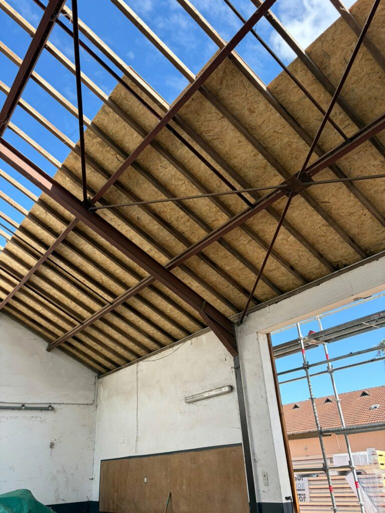 Pose du support OSB sur la charpente du Haras de Cercy-la-Tour, vue depuis l’intérieur